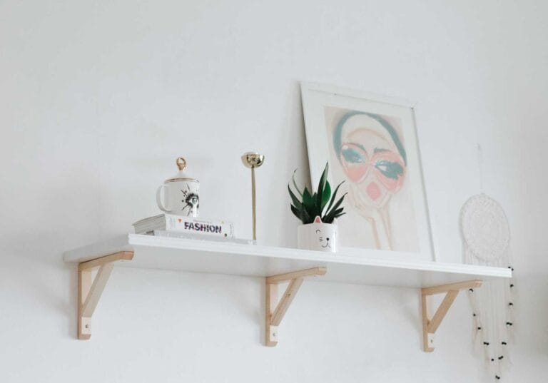 Minimalist white shelf styled with art and accessories from Home Decor Subscription Boxes.