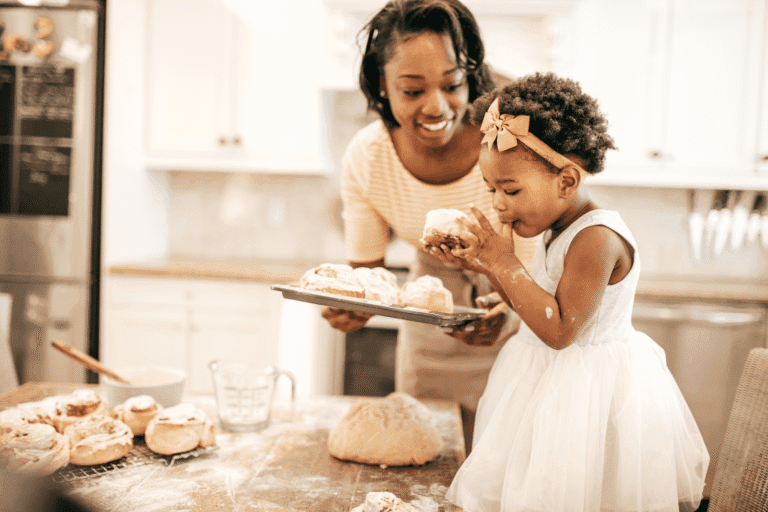Mom and toddler baking cinnamon rolls together in the kitchen as part of a joyful Daily Routine for Stay-at-Home Moms.