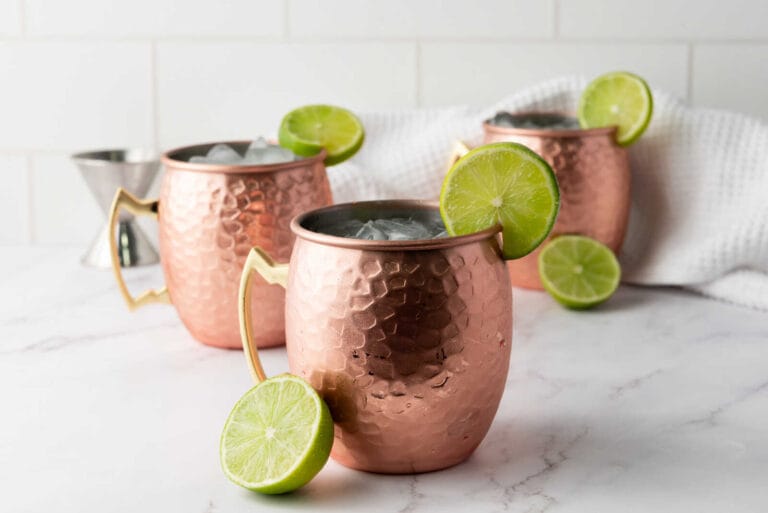 Moscow Mule cocktails in copper mugs with ice and lime slices